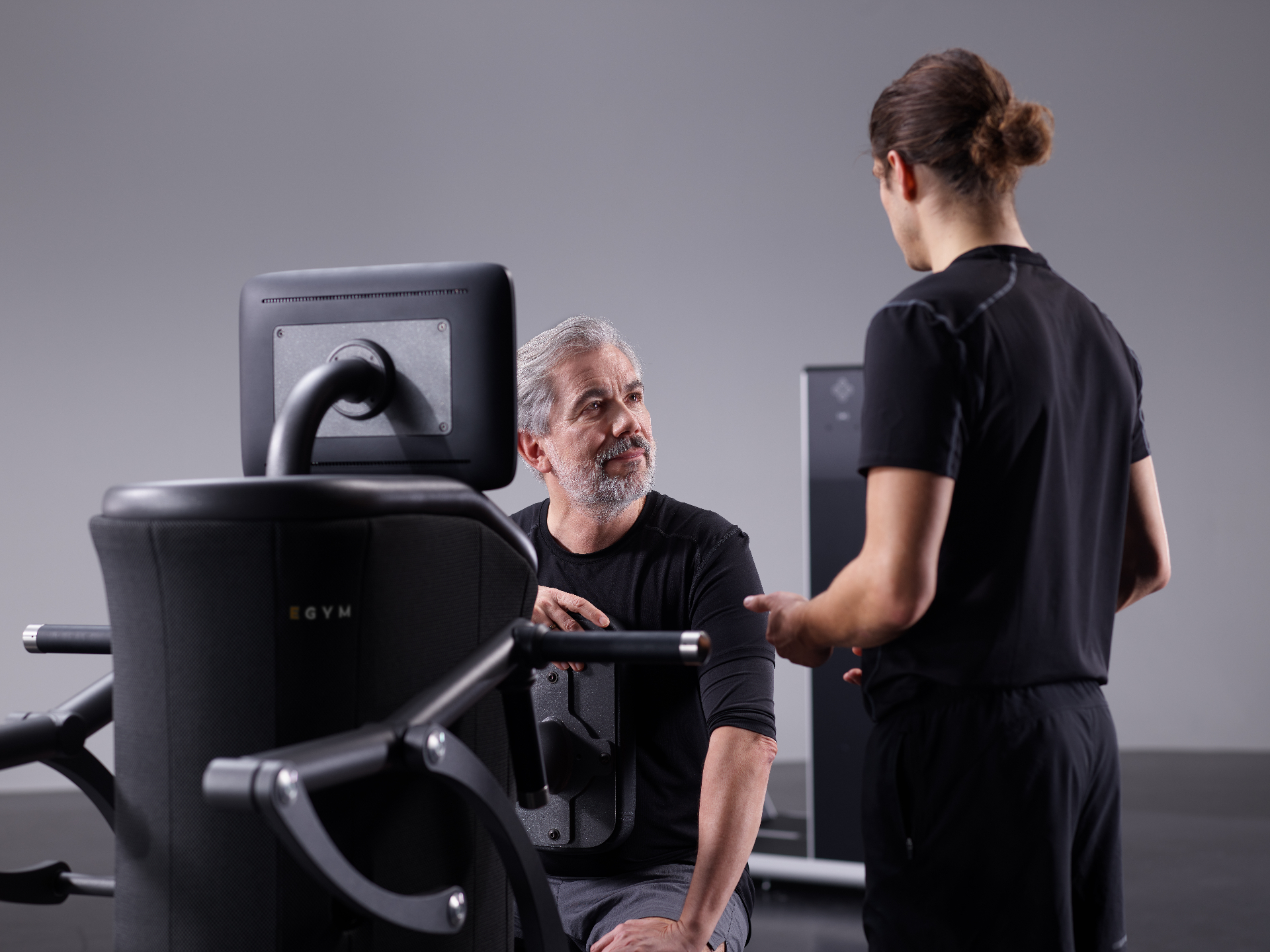 Senior traint op EGYM apparatuur met begeleiding
